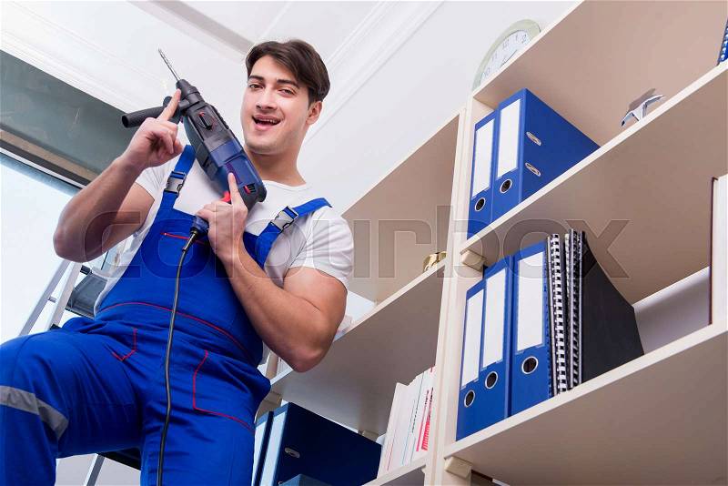 Young worker repairing shelves in office, stock photo