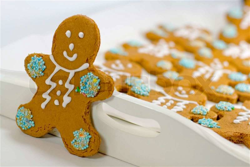Closeup of fresh baked cheerful gingerbread men cookies with decorations, stock photo