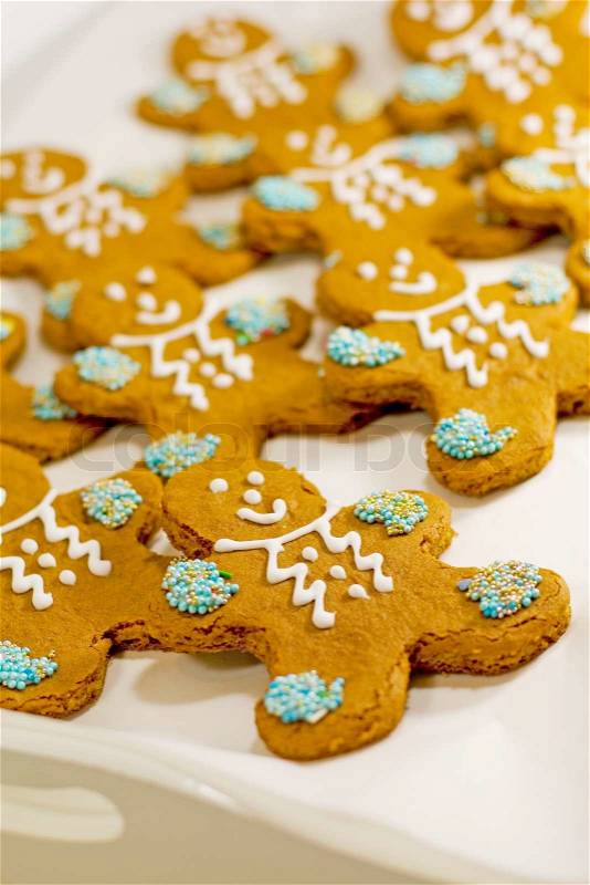 Closeup of fresh baked cheerful gingerbread men cookies with decorations, stock photo