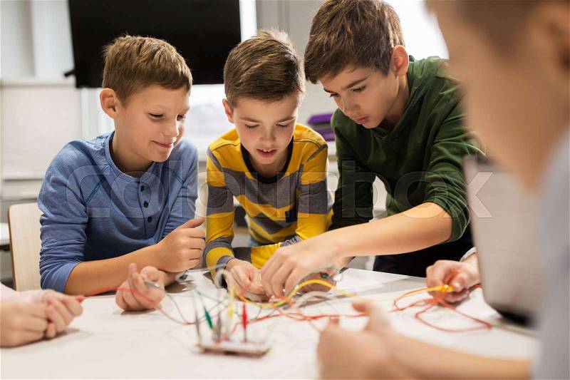 Education, children, technology, science and people concept - group of happy kids with invention kit at robotics school lesson, stock photo