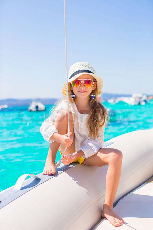 Little girl enjoying sailing on boat in the open sea, stock photo