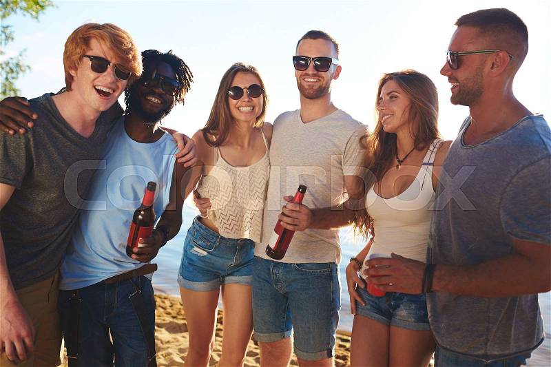 Affectionate buddies with beer enjoying beach party, stock photo