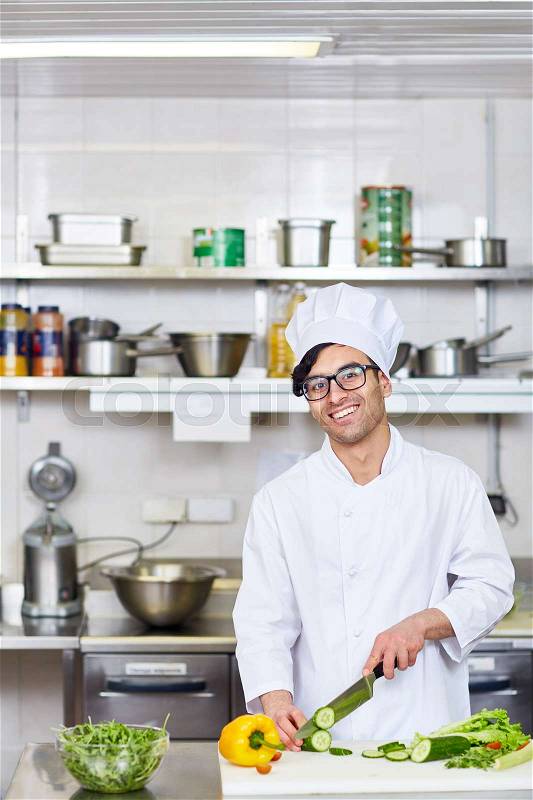 Happy chef working in the kitchen of restaurant, stock photo