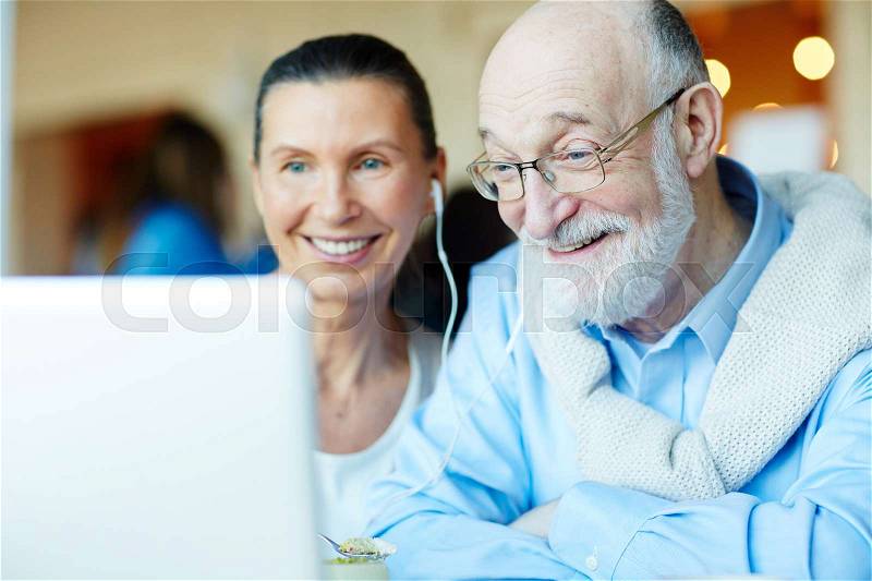 Happy grandparents talking to relatives through video-chat, stock photo