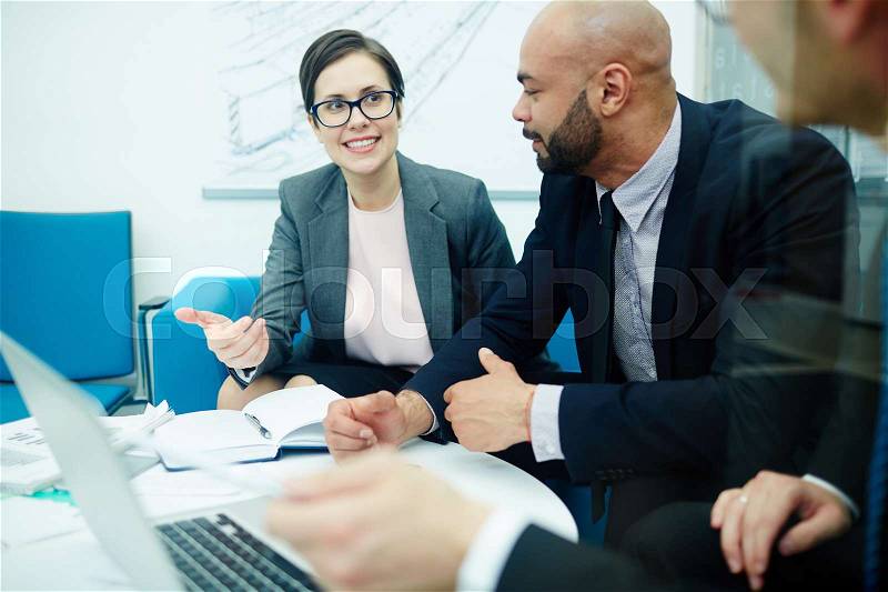 Portrait of three enthusiastic business people discussing startup ideas in office meeting, stock photo