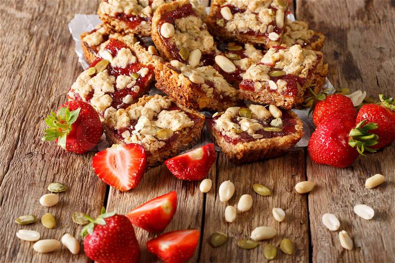 Healthy Oat bars with strawberry jam, seeds and nuts close-up on the table. horizontal , stock photo