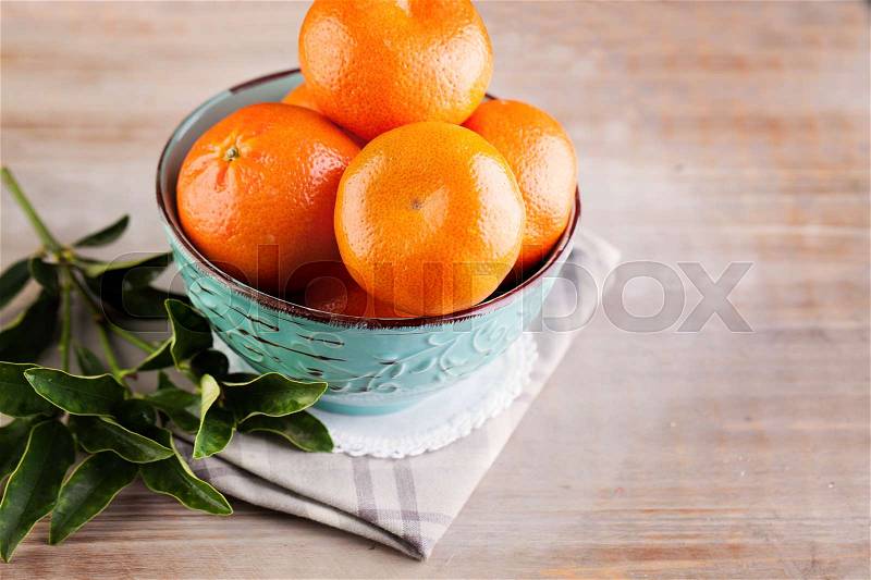 Mandarins Fruit with Green Leaves on Old Rustic Wooden Board Background, stock photo