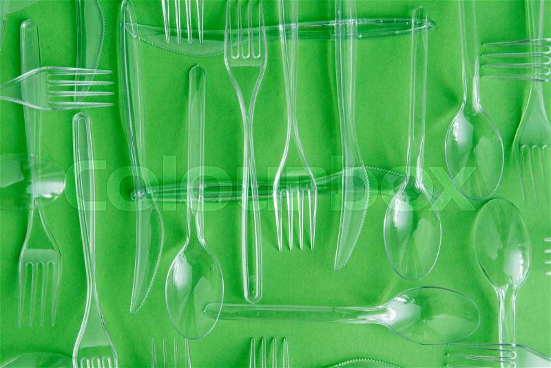 Top view of set of various plastic cutlery isolated on green, stock photo