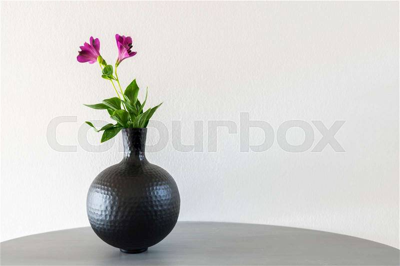 Delicate flowers in round metal vase. , stock photo