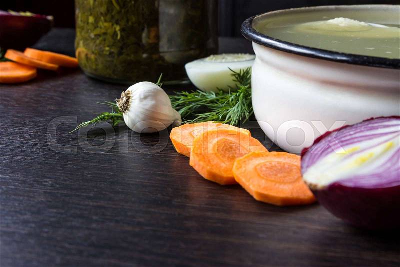 Soup with sorrel, vegetables and boiled egg, red onion, carrots, garlic, dill on dark wooden table, stock photo