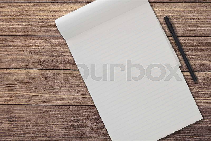Top view of blank ruled notepad and pen side by side on rustic wooden table background template, stock photo