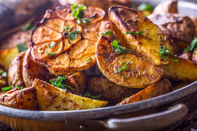 American potatoes. Baked potatoes in peel. Roasted potatoes with garlic spices salt cumin and herbs, stock photo