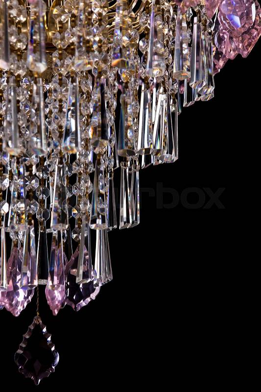 Large crystal chandelier with pink crystals details isolated on black background. Luxury royal expensive chandelier for living room, Hall of celebration, stock photo