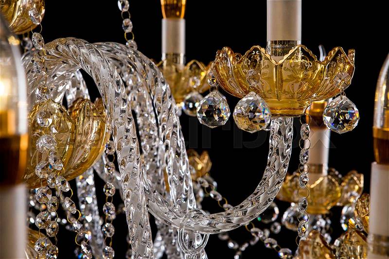 Large crystal close-up chandelier with candles isolated on black background. Luxury royal expensive chandelier for living room, Hall of celebration, stock photo