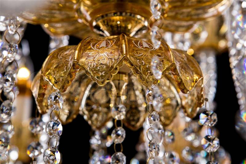 Large crystal close-up chandelier with candles isolated on black background. Luxury royal expensive chandelier for living room, Hall of celebration, stock photo