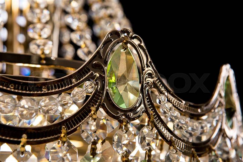 Large crystal chandelier close-up with green crystals isolated on black background. Luxury royal expensive chandelier for living room, Hall of celebration, stock photo