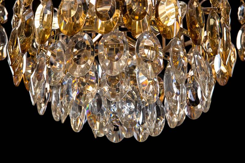 Large crystal chandelier details isolated on black background. Luxury royal expensive chandelier for living room, Hall of celebration, stock photo