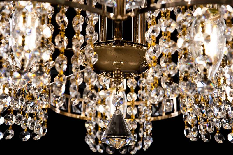 Large crystal chandelier close-up isolated on black background. Luxury royal expensive chandelier for living room, Hall of celebration, stock photo