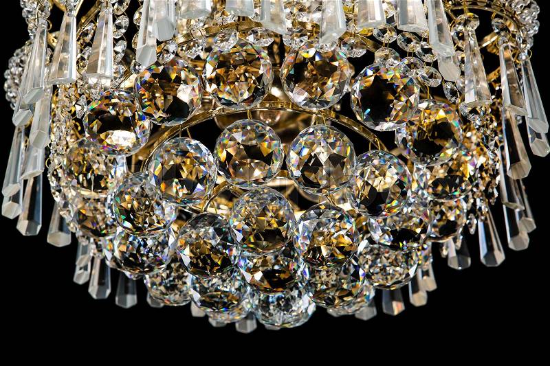 Large crystal chandelier details isolated on black background. Luxury royal expensive chandelier for living room, Hall of celebration, stock photo