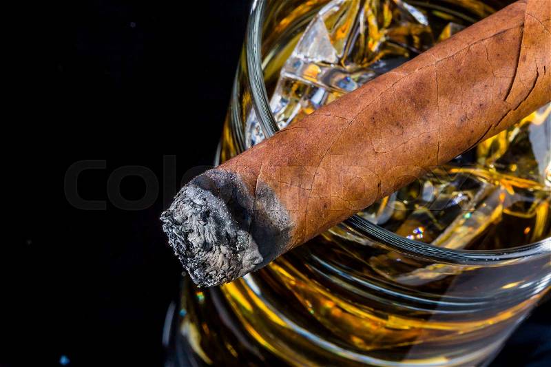 Cigar and whiskey. a symbol photo for addiction and pleasure, stock photo