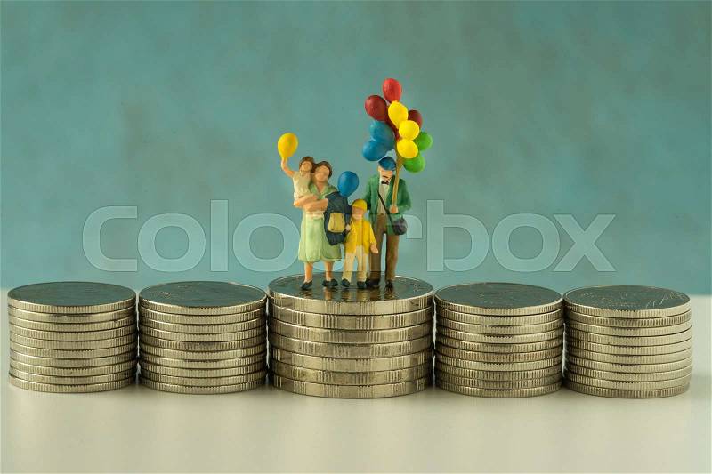 Miniature figure family with balloon standing on stack of coins as financial business growth rising concept, stock photo