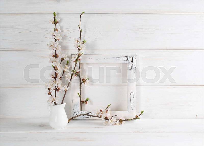 Decorated frame and apricot flowers in home interior on wooden boards in shabby chic style with place for text. Copy space, stock photo