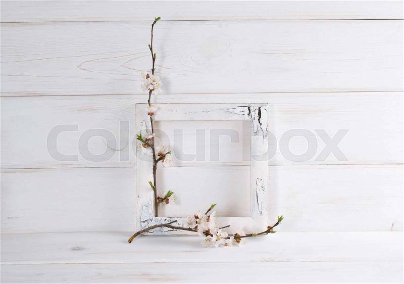 Decorated frame and apricot flowers in home interior on wooden boards in shabby chic style with place for text. Copy space, stock photo