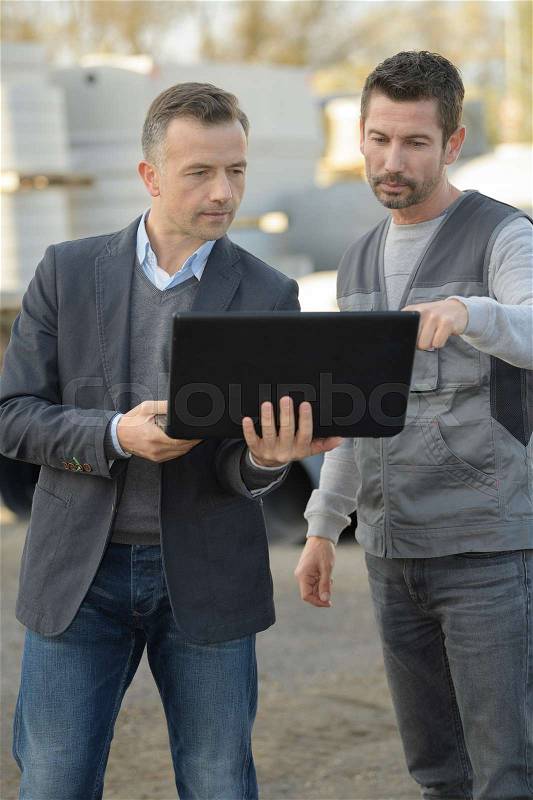 Builder and manager with laptop computer, stock photo