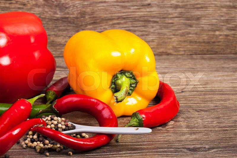 Sweet and spicy peppers on wooden background in studio photo. Raw healthy food, stock photo