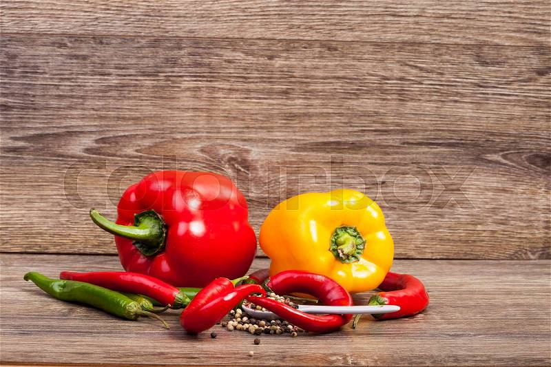 Sweet and spicy peppers on wooden background in studio photo. Raw healthy food, stock photo