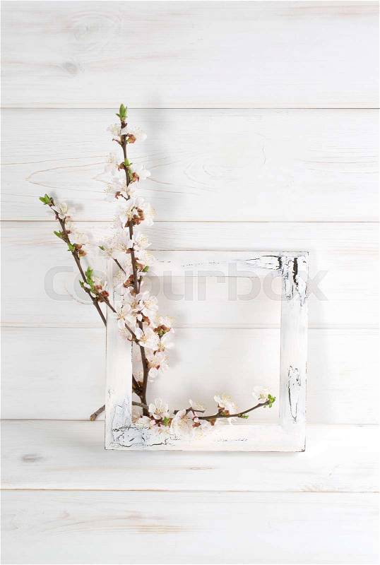 Decorated frame and apricot flowers in home interior on wooden boards in shabby chic style. Copy space, stock photo