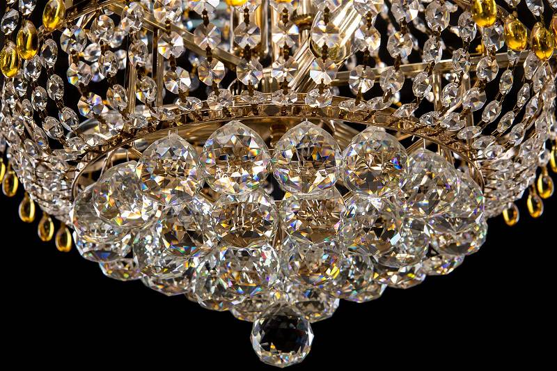 Large crystal chandelier close-up in baroque style isolated on black background. Luxury royal expensive chandelier for living room, Hall of celebration, stock photo