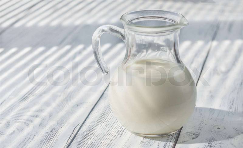 Glass pitcher of milk, stock photo