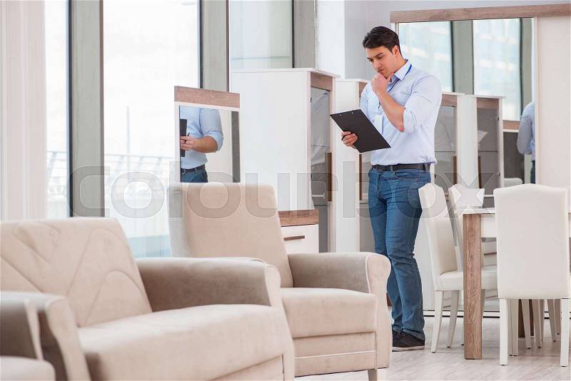Sales assistant in furniture store, stock photo