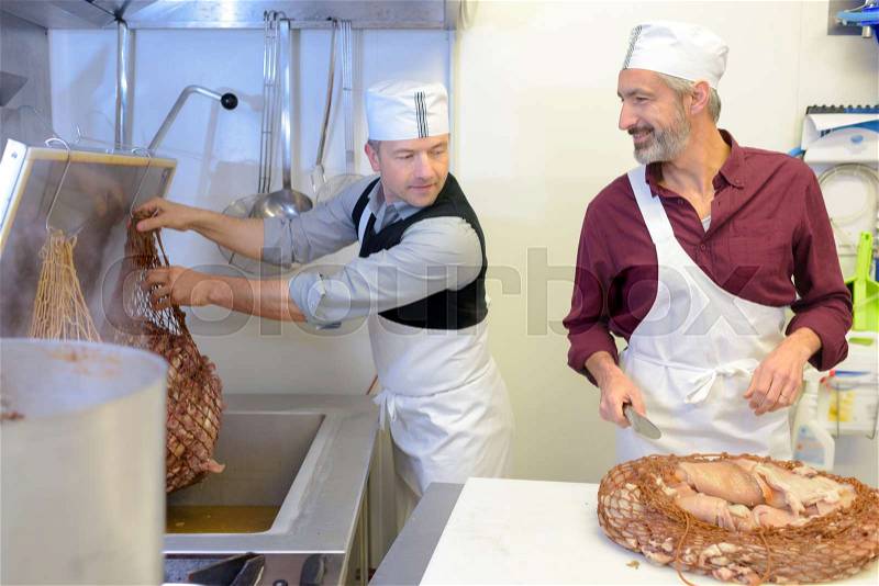 Men working at an industrial kitchen, stock photo