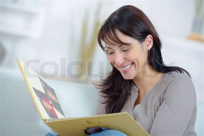 Woman looking at a travel diary memories, stock photo
