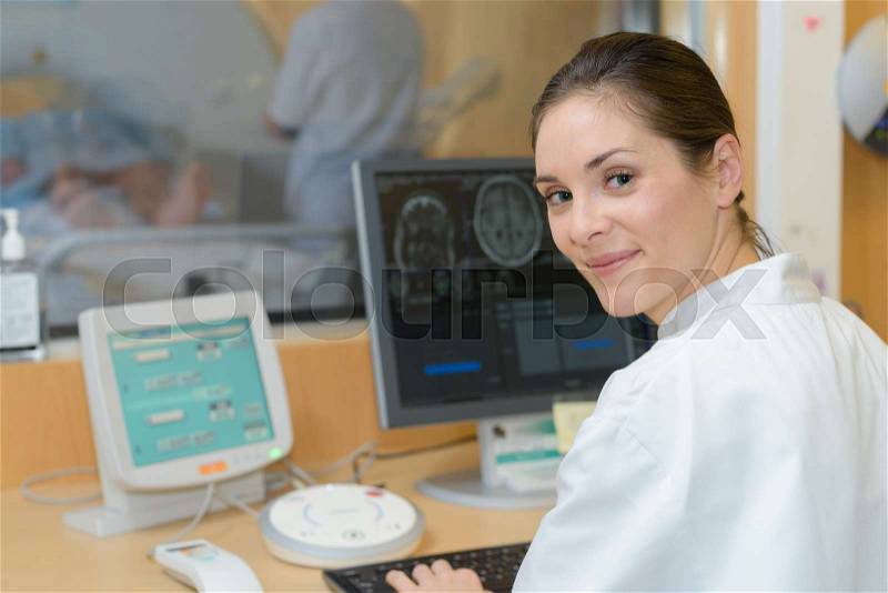 Nurse at computer in radiology department, stock photo