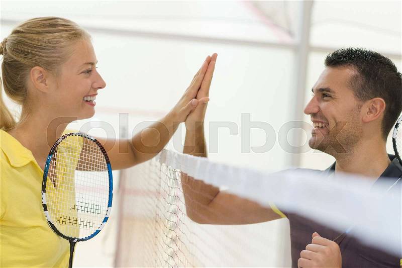 Couple doing high five after badminton match, stock photo