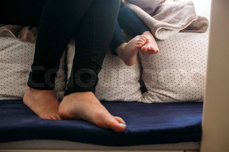 The legs of a little girl and mom, indoors, stock photo