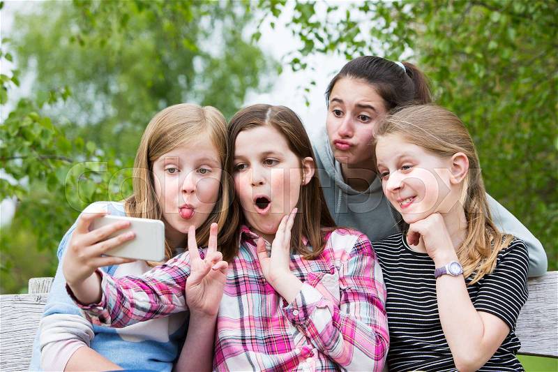 Group Of Young Girls Posing For Selfie In Park, stock photo