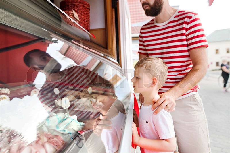 Young father and his little son buying ice cream. Sunny summer day, stock photo