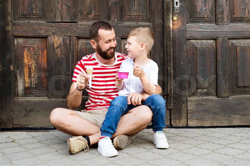Young father and his little son eating ice cream. Sunny summer day, stock photo