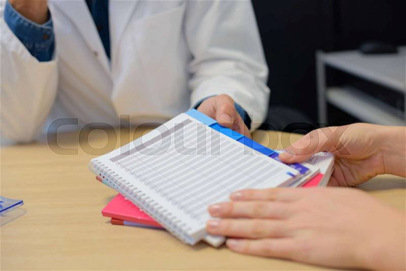 Doctor writes the report in the register, stock photo