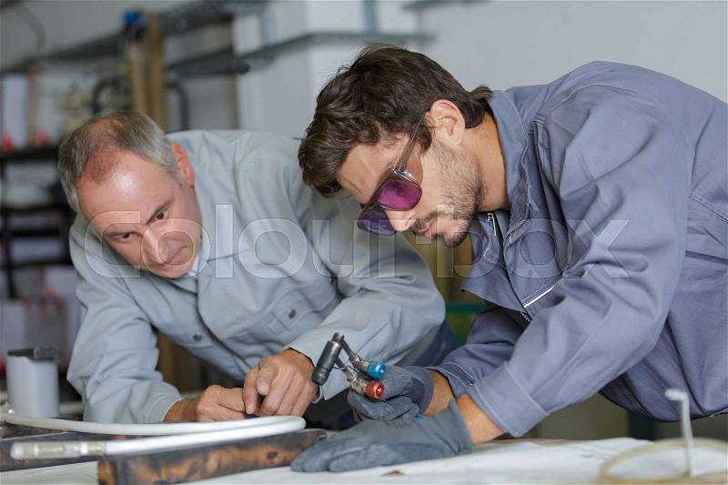 Young man in professional training to become plumber, stock photo
