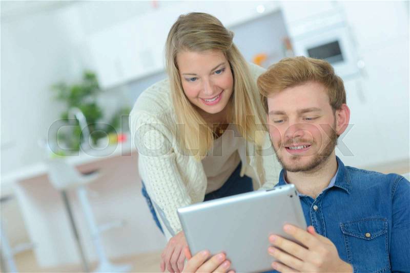 Couple moving home and buying on line with a tablet, stock photo