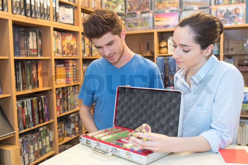 Young beautiful woman shows poker chips in case to customer, stock photo