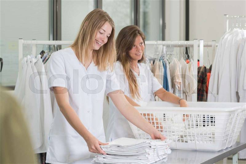 Happy young women laundry workers at the dry cleaners, stock photo