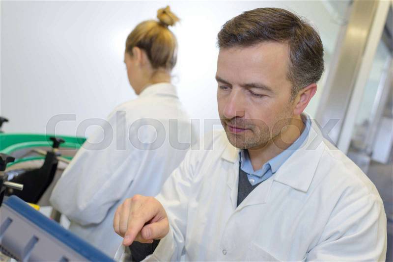 Mechanic using a sturdy touch screen terminal, stock photo
