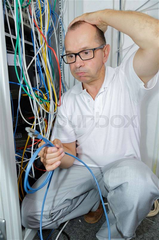 Electrician trying to find the right cable, stock photo