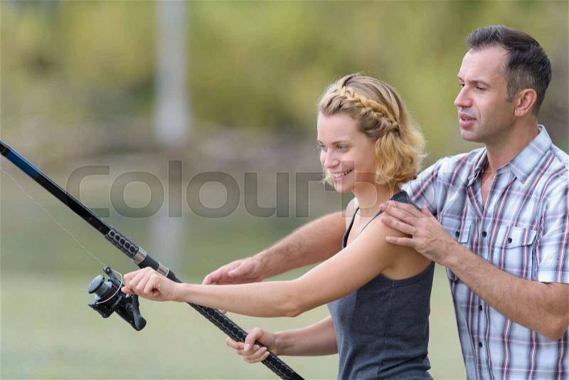 Couple fishing on the banks of the pond, stock photo